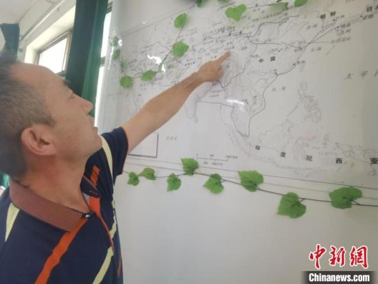 圖為甘肅省社會(huì)科學(xué)院絲綢之路研究所所長(zhǎng)侯宗輝指出《絲綢之路古文明》課題組考察線(xiàn)路。　閆姣 攝