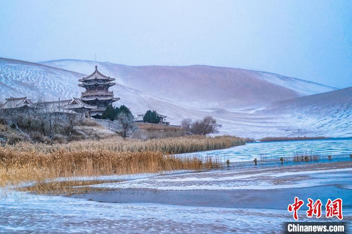 2021年11月28日，雪落鳴沙山月牙泉景區?！⊥醣筱y 攝