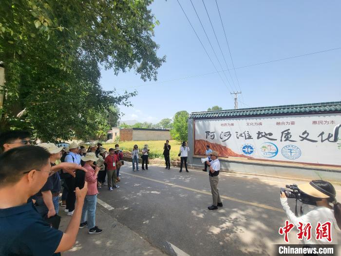 圖為中國(guó)地質(zhì)大學(xué)(北京)教授張緒教介紹村落情況。　胡友軍 攝