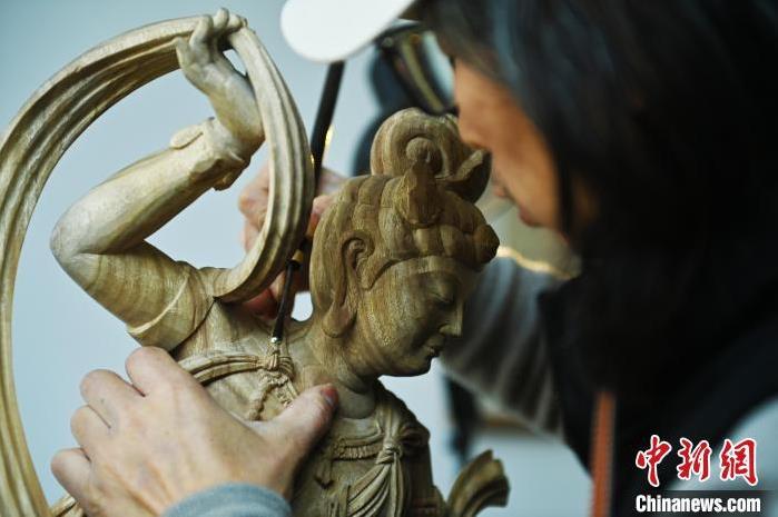 圖為季茂杰進行敦煌元素的木雕創作。李亞龍 攝</p>
<p>