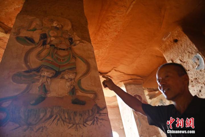 7月15日，甘肅省平涼市涇川縣百里石窟長廊羅漢洞石窟內，該窟文保員郭建平介紹窟內石刻彩繪壁畫。郭建平家中三代人曾自發保護羅漢洞石窟。羅漢洞石窟遺存40余個窟龕，以北魏至清代風格為主。中新社記者 李亞龍 攝</p>
<p>