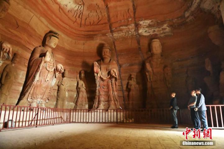 7月15日，游人參觀甘肅省平涼市涇川縣百里石窟長廊中的南石窟寺1號窟。百里石窟長廊位于涇川縣境內，由512個石窟、5眼窟中石井組成，現存王母宮石窟、鳳凰山石窟、南石窟寺、丈八寺石窟、羅漢洞石窟、太山寺石窟等規模較大的石窟群，還有數量眾多的小石窟群。南石窟寺開鑿于北魏永平三年，其中1號窟屬于大型七佛窟，七佛高達6米。中新社記者 李亞龍 攝