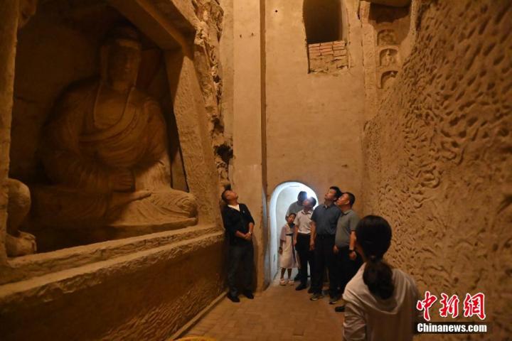 7月15日，游人參觀甘肅省平涼市涇川縣百里石窟長廊中的王母宮石窟。百里石窟長廊位于涇川縣境內，由512個石窟、5眼窟中石井組成，現存王母宮石窟、鳳凰山石窟、南石窟寺、丈八寺石窟、羅漢洞石窟、太山寺石窟等規模較大的石窟群，還有數量眾多的小石窟群。王母宮石窟又名千佛洞，該窟設計宏大，造像生動，窟內擁有造像數百尊，是較為珍貴的佛教文化歷史遺存。中新社記者 李亞龍 攝</p>
<p>