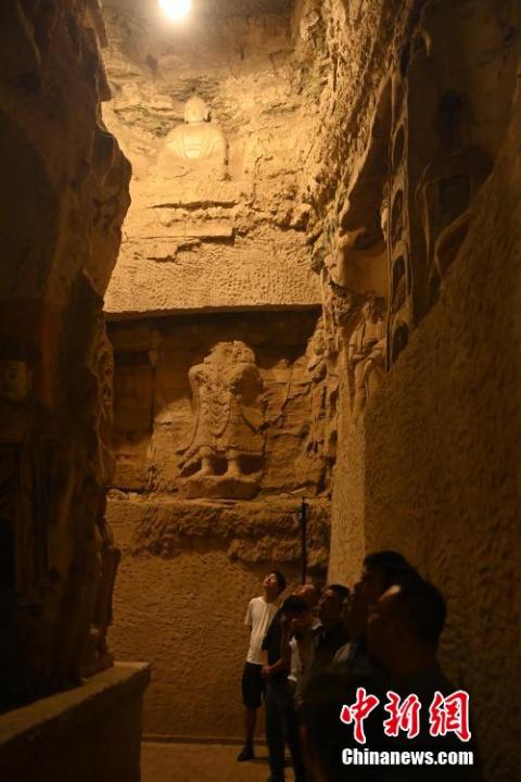 7月15日，游人參觀甘肅省平涼市涇川縣百里石窟長廊中的王母宮石窟。百里石窟長廊位于涇川縣境內，由512個石窟、5眼窟中石井組成，現存王母宮石窟、鳳凰山石窟、南石窟寺、丈八寺石窟、羅漢洞石窟、太山寺石窟等規模較大的石窟群，還有數量眾多的小石窟群。王母宮石窟又名千佛洞，該窟設計宏大，造像生動，窟內擁有造像數百尊，是較為珍貴的佛教文化遺存。中新社記者 李亞龍 攝</p>
<p>