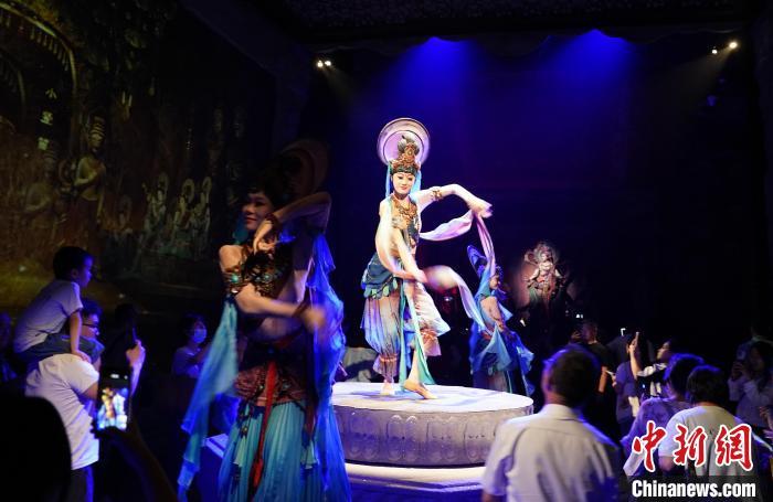 《樂動敦煌》是全球首部洞窟式沉浸體驗劇，利用真人與數字影像虛實交換實現沉浸式體驗。圖為2023年8月28日晚，《樂動敦煌》演出。(資料圖)中新社記者 毛建軍 攝